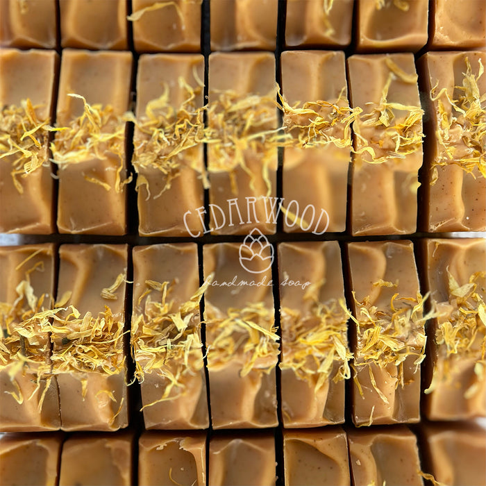 Close-up of orange marigold soap bars with 'Cedarwood' branding.