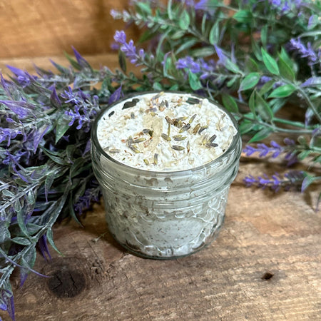 Glass jar of Lavender Sugar body scrub with lavender branches in the background 