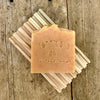 Orange marigold handmade soap bar on wood soap dish